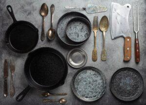Old vintage tableware and kitchen utensils on rustic stone background